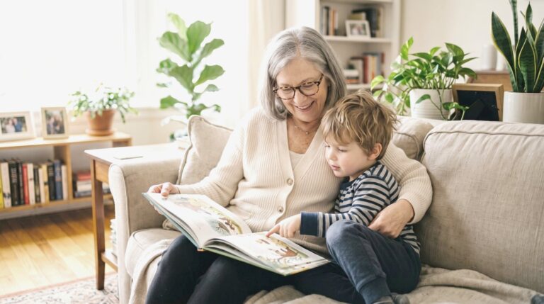 Babcia w okularach czyta wnukowi książkę