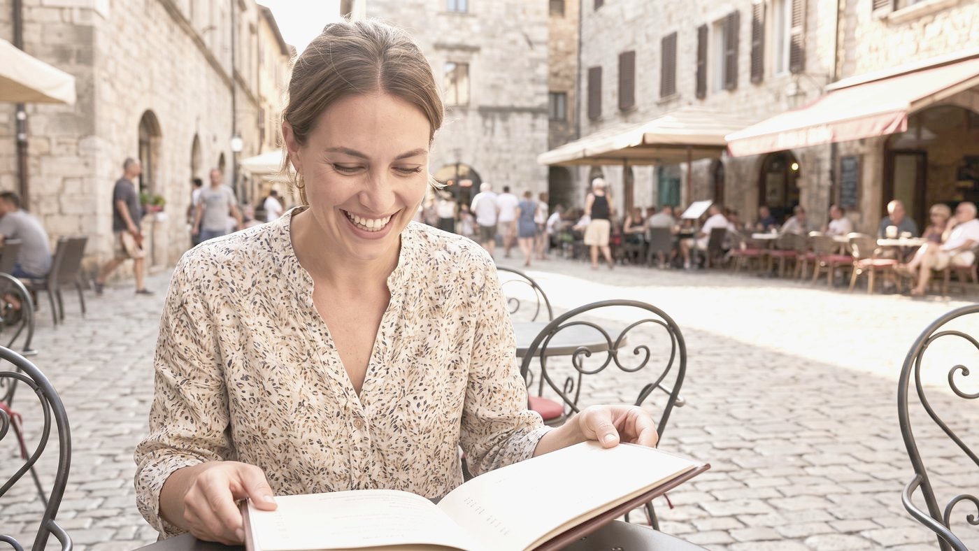 Okulary progresywne Oleśnica Kobieta po czterdziestce czyta menu w kawiarni – ilustracja